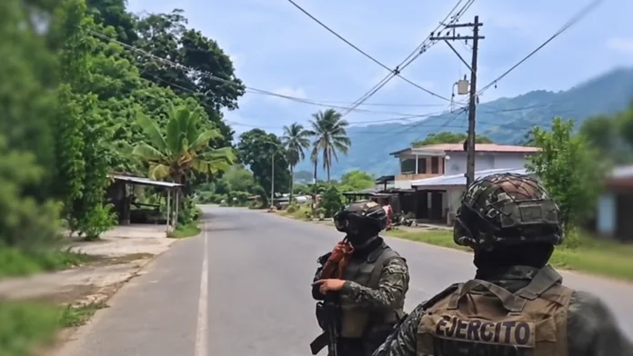 Dos uniformados de la Fuerza Pública permanecen en una vía durante el despliegue de seguridad.