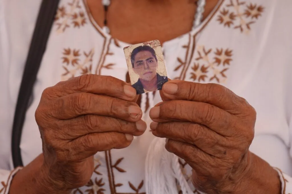 Familiar sostiene fotografía de una persona desaparecida durante jornada de búsqueda humanitaria