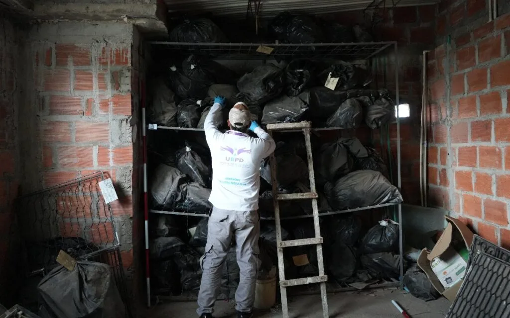 Funcionario de la UBPD revisa contenedores durante búsqueda de personas desaparecidas en el cementerio de Codazzi