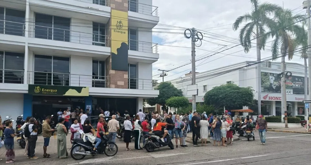 Usuarios y motociclistas frente a una sede de Energua en Valledupar durante jornadas de pago