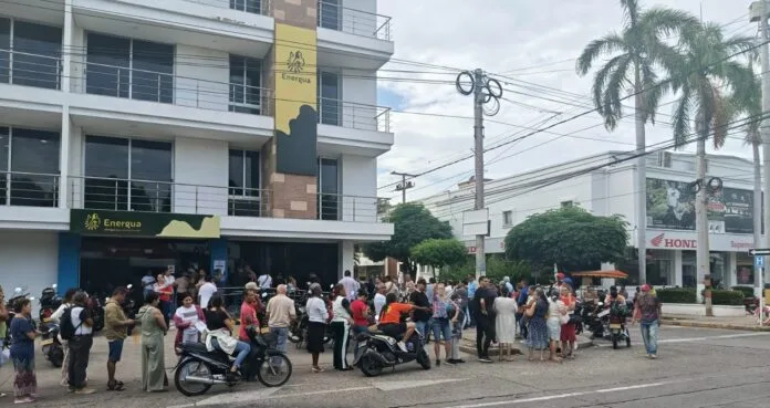 Usuarios y motociclistas frente a una sede de Energua en Valledupar durante jornadas de pago