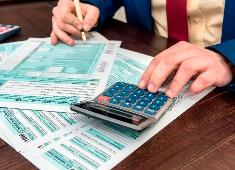 Persona diligencia formularios y calcula valores para la declaración de renta 2026.