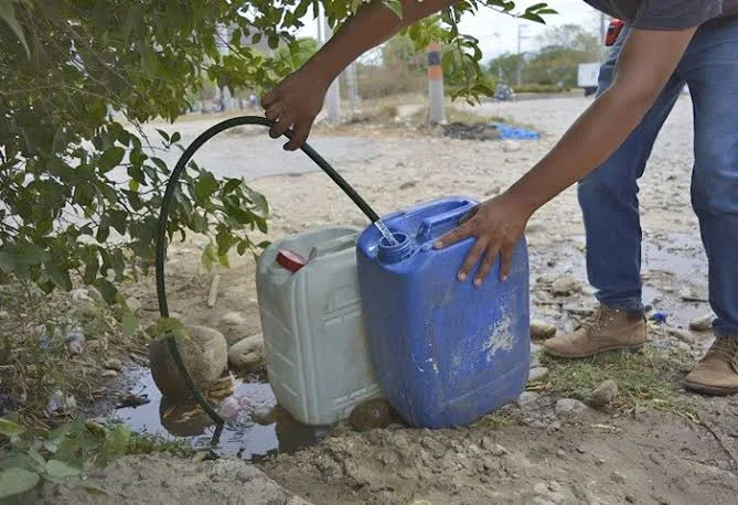 Persona recoge agua en recipientes durante temporada seca en el Cesar