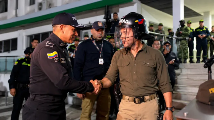 Abelardo de la Espriella con casco del Esmad, pistola al cinto y un uniformado de la Policía Nacional.