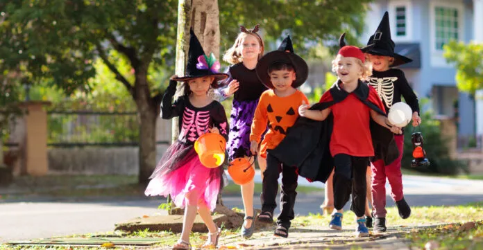 Padres acompañan a niños durante celebración de Halloween.