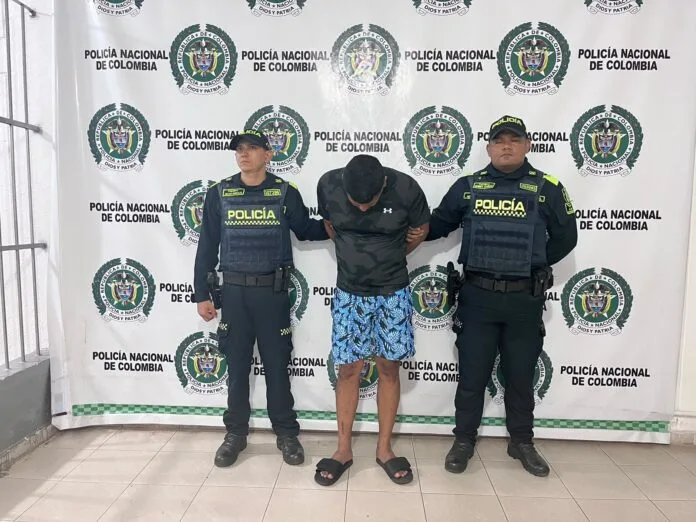 Policías custodian a alias ‘El Guajiro’ tras su captura en Valencia de Jesús, Valledupar, por su presunta participación en un doble homicidio en Santa Marta.