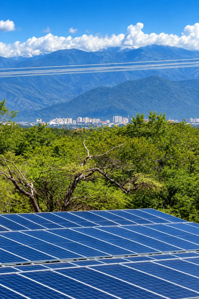Energía solar en el Cesar: paneles fotovoltaicos en una granja de La Paz, con Valledupar y la Sierra Nevada al fondo.
