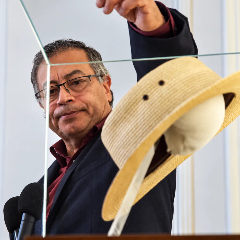 Gustavo Petro observa el sombrero de Carlos Pizarro dentro de una vitrina de exhibición durante un acto institucional.